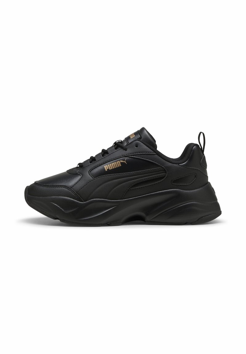 Baskets noires Puma avec semelle épaisse, design à lacets et logo Puma doré sur le côté, montrées en profil sur fond blanc.