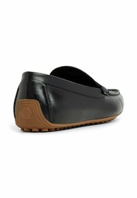 Svarta läder loafers med en slät yta, sydda detaljer och en brun gummisula med ett strukturerat greppdesign.