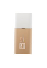 Beige foundationfles met een witte dop, cilinder vorm, met een etiket met tekst in het wit en geel. Compact ontwerp.