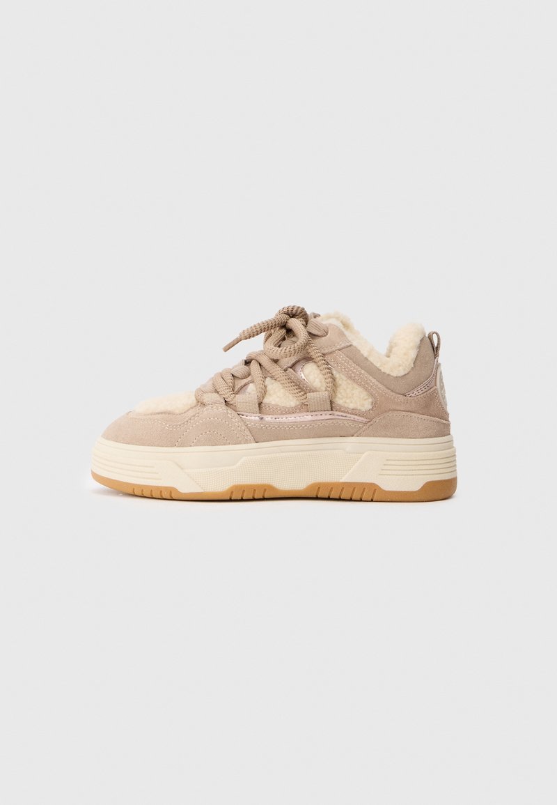 Baskets en daim beige avec semelle épaisse crème, lacets épais beige, et doublure intérieure en laine d'agneau douce crème, ainsi que sur les panneaux supérieurs.