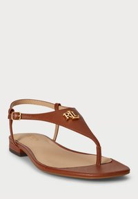 Hnedé kožené šľapky s pozláteným logom "RL", nastaviteľným remienkom na členku, plochou podrážkou a textúrovaným povrchom.