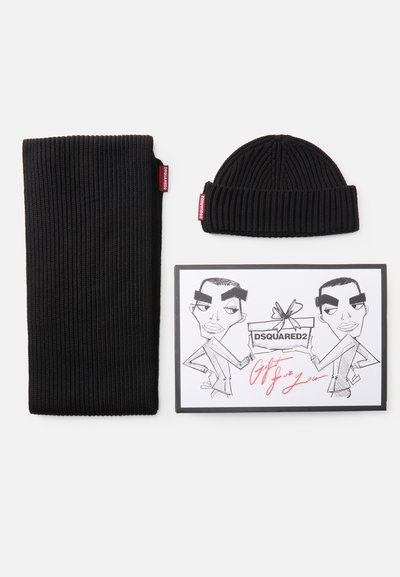 Conjunto de gorro e cachecol de malha canelada preta, acompanhado por um cartão ilustrado em preto e branco com duas figuras e texto vermelho escrito à mão.