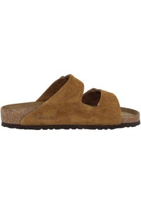Bruine suède sandalen met twee gekruiste banden, kurken voetbed en rubberen buitenzool. Voorzien van een logo aan de zijkant en een gestructureerd oppervlak.