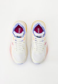 Baskets en mesh blanc avec des accents multicolores en jaune, orange et rose. Dotées de lacets blancs et d'un col rembourré. Marque intérieure visible.