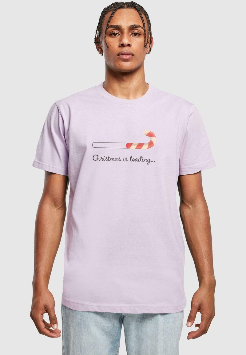 Light purple cotton t-shirt featuring a graphic of a candy cane and text reading "Christmas is loading..." in black. Short sleeves, crew neck.
