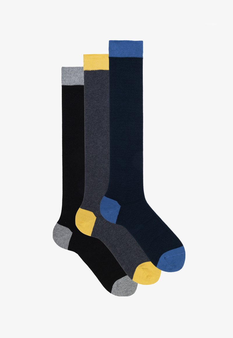 Drei Paar Mid-Calf-Socken. Farben: Schwarz, Dunkelgrau, Marineblau, mit kontrastierenden gelben und blauen Bündchen und Zehenakzenten. Glatte Textur.