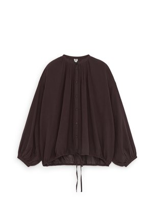 Blouse ample marron foncé avec boutons, manches longues bouffantes, poignets froncés et ourlet à cordon, présentée sur fond blanc.