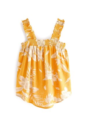 Peto de bebé amarillo con estampado floral blanco, corpiño fruncido y tirantes con volantes sobre fondo blanco.