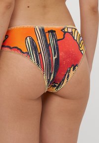 Barevné bikini kalhotky s designem západu slunce a kaktusy. Jsou vyrobeny z měkkého materiálu, mají kontrastní švy a vysoký střih.
