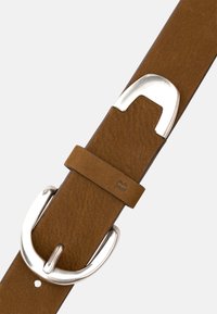 Brun läderbälte med texturerad yta och en silverfärgad metallspänne. Har en ögla och en lätt accent med en pr präglad bokstav.