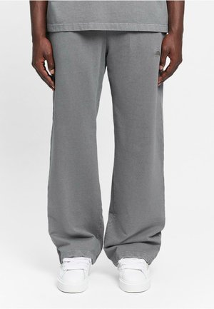 Gray cotton pants with a loose fit, featuring a small logo detail on the pocket, paired with white sneakers. Smooth texture and straight leg design.