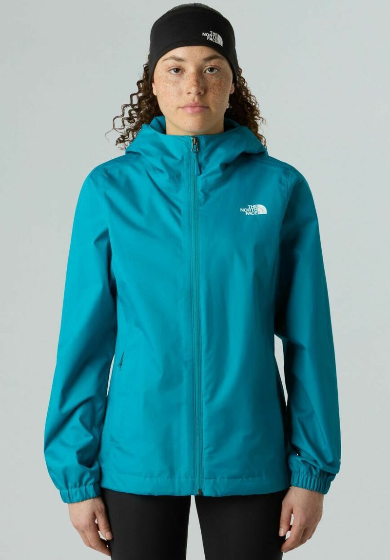 Giacca impermeabile color turchese con cappuccio, zip frontale completa, polsini elastici e logo sul petto. Tessuto morbido e leggero.