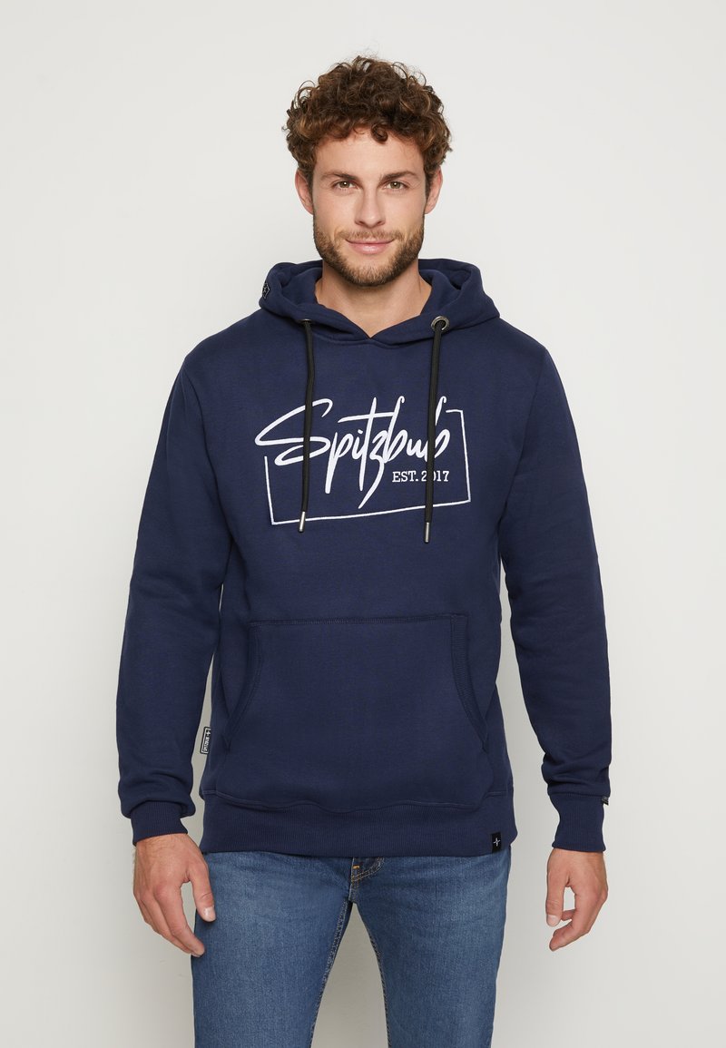 Marineblauwe hoodie met een voorzak, verstelbare trekkoorden en witte grafische tekst "Spitzbub EST. 2017" op de borst. Zachte stoftextuur.