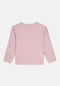 Koszulka z długim rękawem z miękkiej, różowej bawełny, z okrągłym dekoltem i prostym wykończeniem. Tył jest gładki, bez dodatkowych detali czy wzorów.