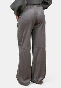 Pantaloni larghi grigi realizzati in tessuto morbido e liscio, dotati di una vita elasticizzata e tasche laterali. Caratterizzati da un design pulito e minimalista.