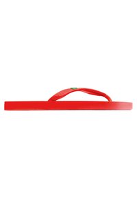 Chanclas rojas con suela plana y una tira texturizada. Presentan un acento verde en la unión de la tira y la suela.