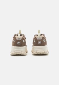 Vista posteriore di sneakers marroni con tomaia in suede e mesh, suola beige chunky e linguette di tiraggio, dotate di accenti riflettenti.