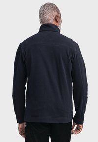 Navy Fleece-Pullover mit hohem Kragen, langen Ärmeln und einem schlichten Design. Weicher Stoff und gerade Saumschnitt, ohne sichtbare Hardware.