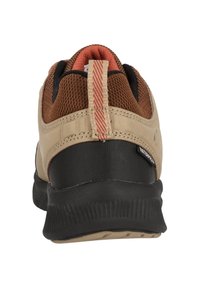 Scarpa impermeabile marrone e nera con tomaia in rete, suola in gomma testurizzata e linguetta sul tallone a strisce rosse. Presenta un design curvo nella parte posteriore.