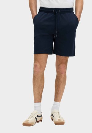 Marineblå shorts lavet af blødt stof, med elastisk talje og snøre. Kombiner med afslappede sneakers og hvide sokker.