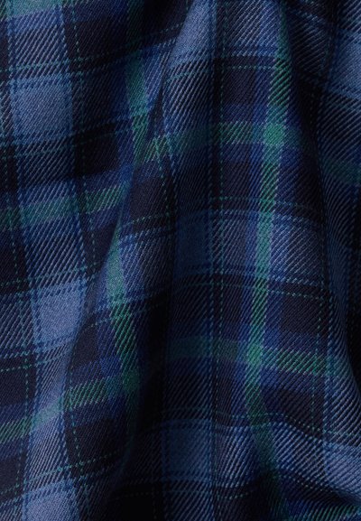 Ύφασμα καρό ταρτάν σε μπλε και πράσινο με διαγώνια υφή ύφανσης, που δείχνει πτυχώσεις και σκιές σε κοντινή λεπτομέρεια.