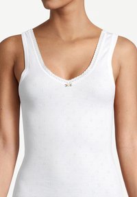 Top in cotone bianco con scollo a V, bordino in pizzo e motivo floreale perforato, caratterizzato da un piccolo dettaglio floreale verde al centro.