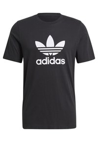 Černé bavlněné tričko s krátkými rukávy, se bílým logem Adidas a třemi vodorovnými pruhy nad logem.