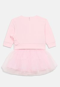 Ροζ φόρεμα με απαλό, μονόχρωμο κορσέ και φούστα από στρώσεις τούλι. Ο κορσές έχει φερμουάρ στο πίσω μέρος και βολάν στη μανσέτα.