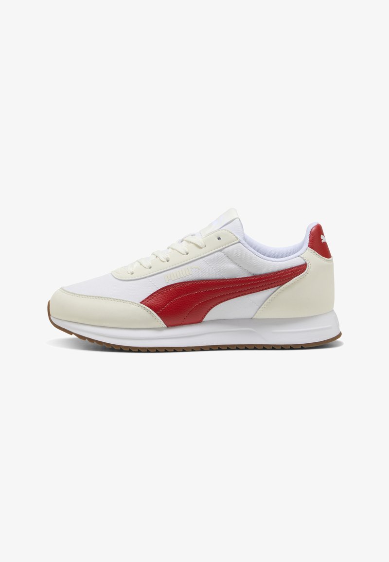 Baskets basses blanches et beiges avec bande rouge Puma, lacets blancs et semelle en gomme, vues de côté sur fond blanc.
