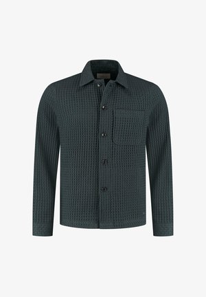 Dunkelgrünes, strukturiertes Button-Up-Hemd mit einer Tasche, langen Ärmeln und kragenförmigem Halsauschnitt. Der Stoff hat ein Waffelmuster und einen subtilen Glanz.