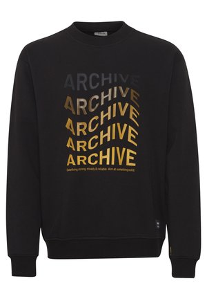 Mustmustri kaelusega must kleit. Omab kihilist teksti "ARCHIVE", mis on erineva fondi suuruse ja metalsete kuldsete toonidega. Koonilised varrukad ja äär.