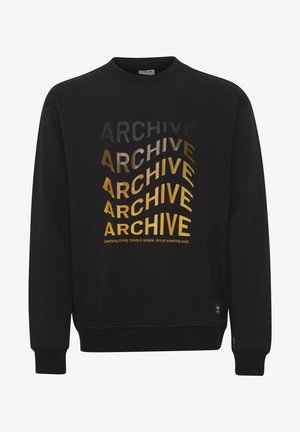 Mustmustri kaelusega must kleit. Omab kihilist teksti "ARCHIVE", mis on erineva fondi suuruse ja metalsete kuldsete toonidega. Koonilised varrukad ja äär.