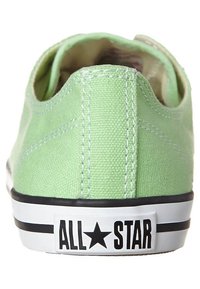 Grüner Canvas-Sneaker mit abgerundetem Hinterteil, weißer Gummisohle, schwarzen Streifen und "ALL★STAR"-Markierung an der Ferse. Strukturiert Oberfläche.