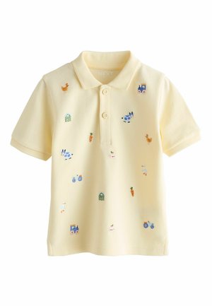 Gelbes Polohemd aus strukturiertem Stoff, mit bunter Stickerei von Tieren, Karotten und einem Traktor, versehen mit einer Knopfleiste mit zwei Knöpfen.