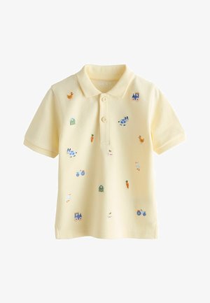 Gul poloshirt lavet af tekstureret stof med farverig broderi af dyr, gulerødder og en traktor, med en to-knaps slids.