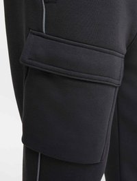 Svarta cargobyxor i mjukt, stretchigt material, med en stor sidoficka med lock och grå accenter i sömmarna.