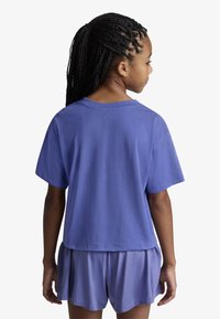 Μωβ βαμβακερό μπλουζάκι με χαλαρή εφαρμογή, κοντά μανίκια και στρογγυλή λαιμόκοψη, συνδυασμένο με αντίστοιχα μωβ σορτς λεβάντας, και τα δύο με απαλή υφή.