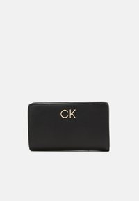 Black leather wallet with a smooth texture, featuring a gold "CK" logo on the front. Compact rectangular shape with rounded edges.
