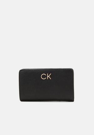 Black leather wallet with a smooth texture, featuring a gold "CK" logo on the front. Compact rectangular shape with rounded edges.