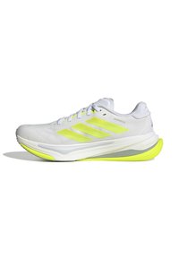 White athletic shoe with yellow accents, textured upper, three stripes design, cushioned sole, and prominent heel detailing.