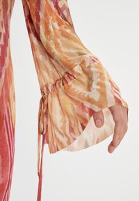 Langarmbluse aus leichtem, durchscheinendem Stoff mit einem abstrakten Muster in warmen Farbtönen von Orange, Pink und Creme, mit gerafften Manschetten.