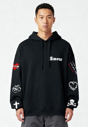 Black hoodie featuring a front pocket. Decorated with white and red text, heart, and skull graphics on sleeves. Soft material, relaxed fit.