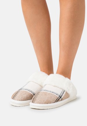 Tan and white plaid slippers with a white faux fur cuff and a flat sole. Soft texture with a rounded toe design.