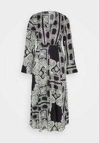 Robe noire à manches longues présentant un motif cachemire et géométrique en blanc. Design à col en V avec une taille cintrée et un bas fluide.