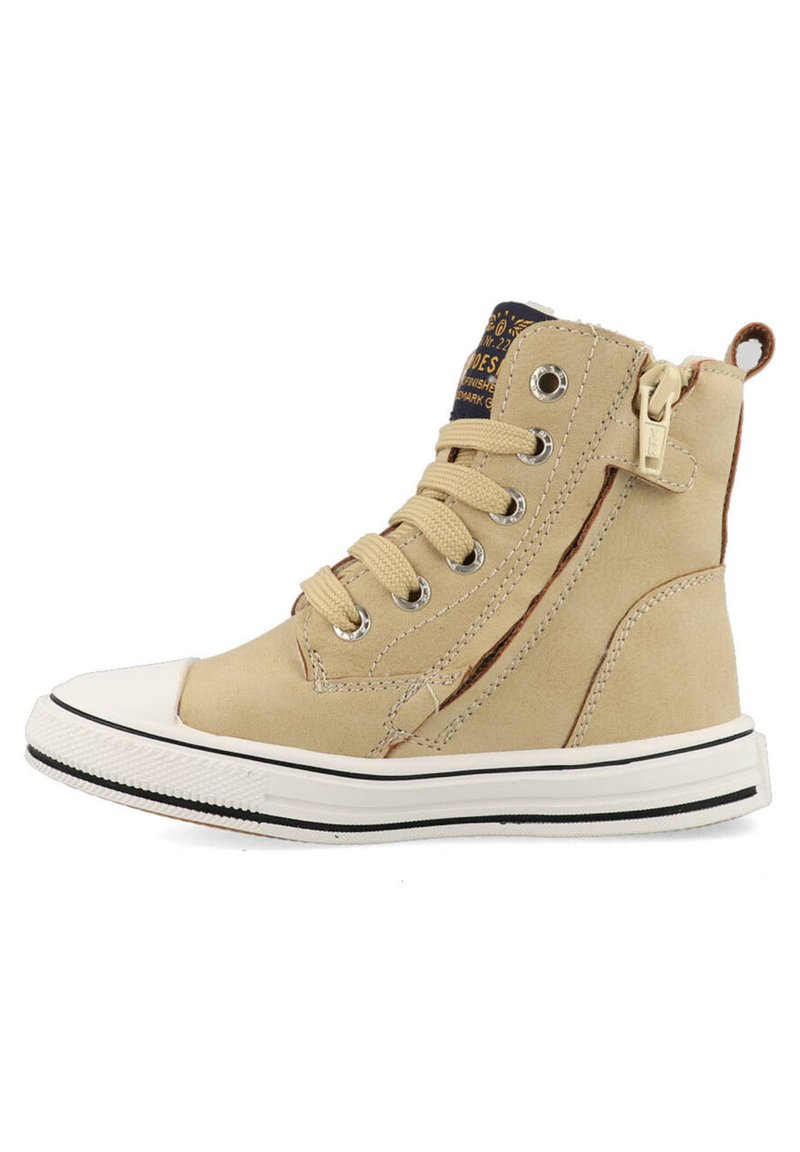 Hoge beige sneaker van suede met een contrasterende zwarte en witte rubberen zool, voorzien van een vetersluiting en een ritssluiting aan de zijkant.