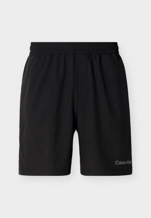 Pantaloncini neri con vita elastica e tasche laterali, lunghezza fino al ginocchio, con piccolo logo Calvin Klein sulla parte inferiore della gamba sinistra.