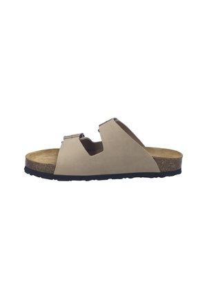 Beige slide sandal with cut-out design, soft upper material, cork footbed, and textured black rubber sole for grip. No visible hardware.