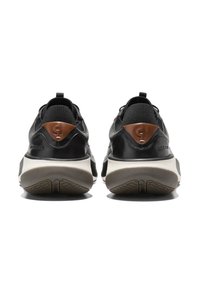 Schwarze Lederturnschuhe mit mattem Finish, ausgestattet mit einem braunen Lederakzent an der Ferse und einer strukturierten Gummisohle für besseren Halt.