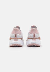 Baskets légères avec une tige en mesh blanche, accentuées de détails roses et beige. Elles présentent une semelle texturée et une languette au talon.
