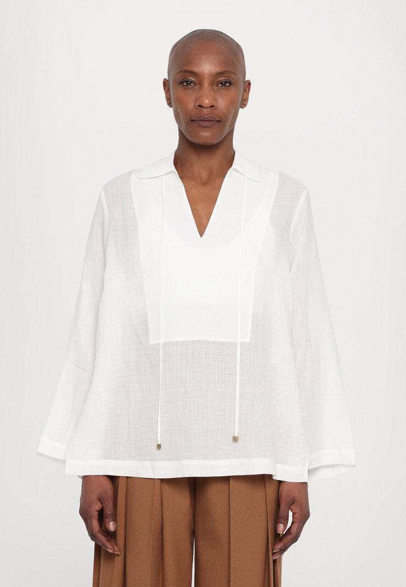 Blusa bianca in lino con scollo a V e colletto, caratterizzata da un dettaglio sul pannello frontale e coulisse. Maniche lunghe e ampie con una leggera lucentezza.